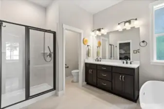Primary bath features free standing tub, heated towel rack and walk in closet (opposite the vanity).