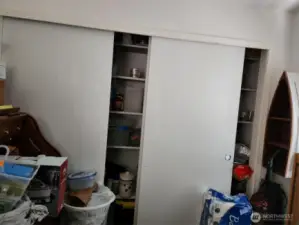 Office/den has extra shelving in the closet for storage.