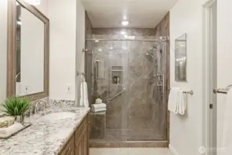 Primary bathroom: Tiled step-in shower with seat, Tiled flooring, Bidet toilet, Updated finishes