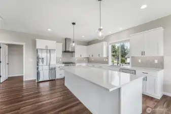 The open concept kitchen with eating space, quartz countertops and stainless steel appliances make this kitchen an entertainer’s dream.