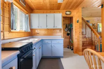 Cabin Kitchen has Propane Refrigerator, Range / Oven, Microwave. Large storage pantry. Dining table, Kitchen and great room open tp high ceilings . Cedar paneling throughout.