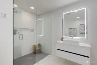 Bathroom features a ceramic tile walk-in shower, a floating quartz vanity and a daylight mirror.