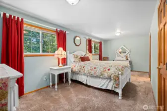 Tranquil bedroom with plush carpet and lush outdoor views.