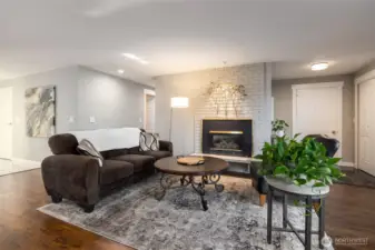 Engineered hardwood flooring, natural gas fireplace, and open living area.