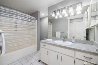 Full guest bath with granite counter, tile floor, tub/shower.