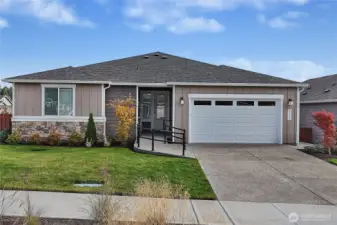 Less than 1-year new home in Ovation at Oak Tree. A wonderful 55+ active community located in Lacey, WA. The concrete ramp with railing provides easy access.  No stairs out front!