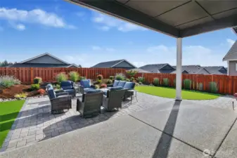 Large paver patio with tranquil fountain in the background.
