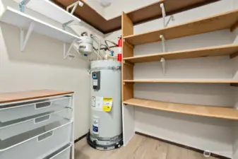 Large walk-in pantry with built-in shelving and new hot water heater.