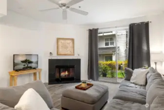 Spacious living area with wood burning fireplace and celling fan.