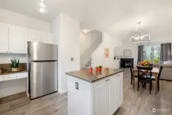 Another view of the kitchen with a desk area to the left of refrigerator.