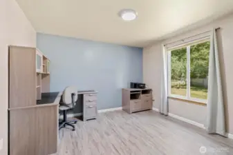 This spacious secondary bedroom is filled with natural light thanks to the large window overlooking the private front yard. A calming accent wall adds a modern touch, while the versatile layout easily accommodates a guest bed, creative space, or a full home office setup. Durable flooring and neutral finishes make this room move-in ready for whatever your lifestyle needs.