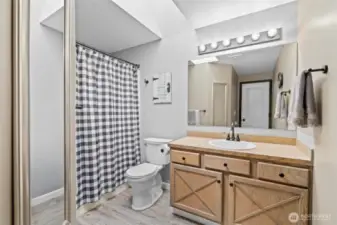 The main bathroom is light and bright, thanks to a large skylight that fills the space with natural light. It features a full tub and shower combo, updated fixtures, and a spacious vanity—perfect for guests or everyday living.