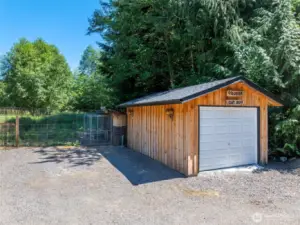 This versatile detached one-car garage offers additional storage or workspace, and just behind it, the fenced chicken coop is ready for your backyard flock.
