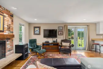 Spacious family room with cozy wood fireplace and French doors leading to the massive back yard.