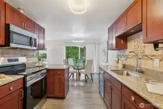 Maple cabinetry, slab granite countertops, and stainless steel appliances make this kitchen a dream to cook in!