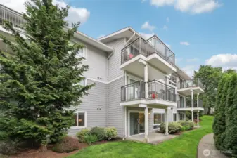 The patio looks out to tranquil grounds and lush plantings.
