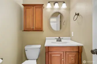 Main level powder room conveniently located between formal, informal spaces and kitchen area.