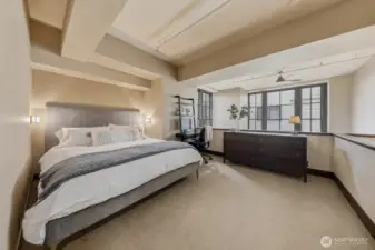 Spacious primary bedroom with 20' ceilings create a wonderful open atmosphere.