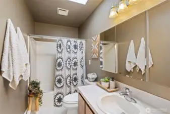 A skylight in the main bathroom transforms a usual space into a serene, light-filled sanctuary with a lookout to the sky. Here, a simple soak in the tub becomes a truly immersive, tranquil experience with glimpses of clouds by day or twinkling stars at night.