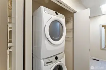 This laundry area, located off the hallway, keeps the household chores tucked behind doors and away from main living areas. Additional shelving on each side of the modern, stacked washer and dryer provides extra storage, functionality and organization. The gas furnace is located in a separate closet next to the laundry. An exceptional value, gas utilities are covered by the monthly HOA dues.