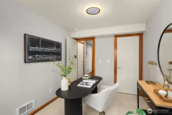 Main level bedroom offers versatility with access via a slider to the fenced-in backyard.