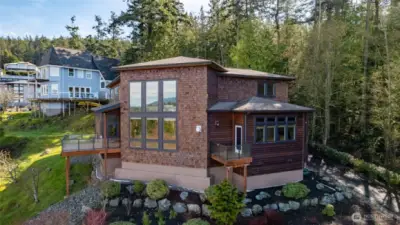 Soaring windows in the double height living room and dining room maximize Westerly light and open up the home to the amazing view. Adorable private balcony seen here off of the primary suite.