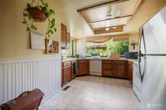 Fully-applianced kitchen w/ large windows overlooking backyard