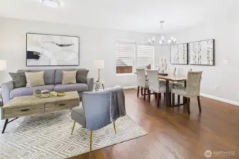 This beautifully staged open-concept living and dining space offers the perfect blend of function and style. Rich hardwood floors, large windows, and designer lighting set the tone for everyday comfort and effortless entertaining.