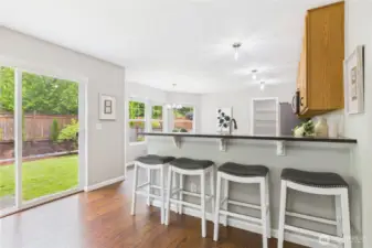 This charming breakfast bar is the perfect spot for casual meals or morning coffee, with stylish bar seating and serene views of the lush, fully fenced backyard. The sliding glass door offers seamless indoor-outdoor living.