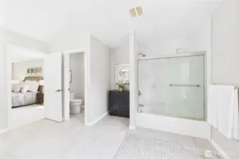 Unwind in the remodeled primary bath, featuring a large vanity, modern tile flooring, and a sleek tub/shower combo with marble tile accents. A calming space with elegant design and generous proportions.