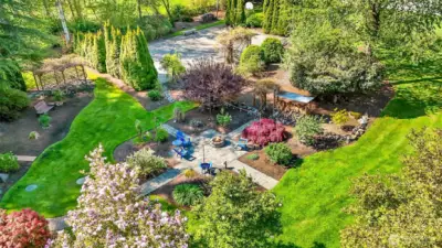 This view shows the firepit, sport court and grape arbor