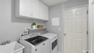 The utility room has a deep sink, cabinets and the Maytag washer and dryer remain with the home.