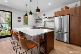 Built in cookbook shelving on one side of island while the other has a built in KitchenAid microwave.