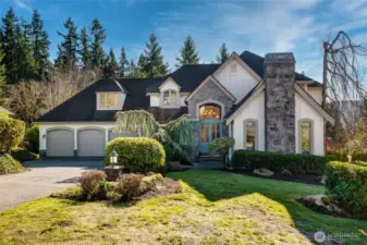 Stunning Carlton Heights home in Sammamish showcasing timeless curb appeal, a stately stone façade, lush mature landscaping, and a spacious three-car garage, where elegance meets everyday functionality.