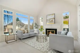 Sun-drenched living room with soaring ceilings, expansive windows, and a cozy fireplace An elegant space designed for both relaxed living and entertaining.
