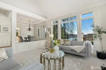 Another view of the expansive living room with walls of windows framing tranquil water views.