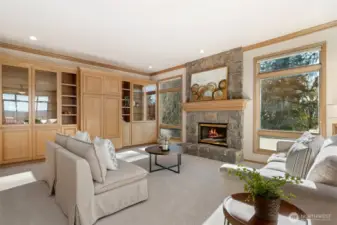 Inviting family room featuring custom built-ins and a stunning stone fireplace providing a warm and welcoming space.