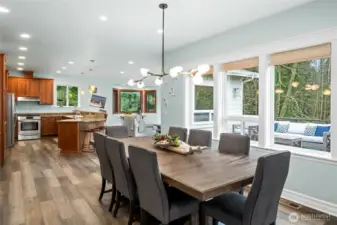 Generous formal dining space with large windows overlooking the deck and wooded greenbelt, perfect for gatherings and holiday dinners.