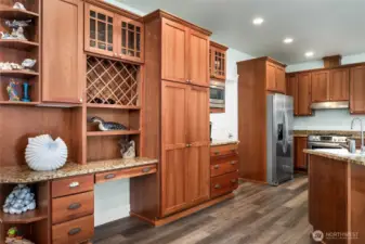 Custom cherry cabinetry with built-in storage, wine rack, and display shelving, blending beauty and functionality.