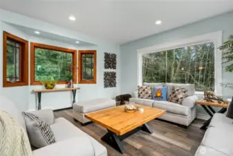 Flexible den or sitting area filled with natural light and serene forest views—ideal for reading, relaxing, or a home office.