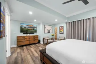 Spacious primary bedroom with crown molding, ceiling fan, and peaceful views creating a comfortable retreat.