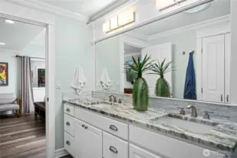 Elegant primary bathroom with dual vanities, granite countertops, and abundant storage.