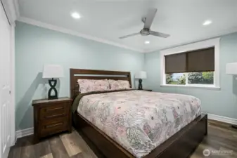 Bright and comfortable secondary bedroom with ceiling fan, large window, and ample closet space.