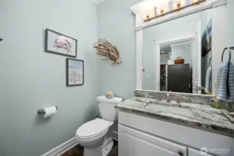 Stylish main-level powder room with granite vanity, modern fixtures, and elegant trim details.
