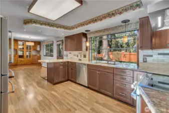 Generous kitchen with abundant cabinetry, expansive granite countertops, and a practical layout designed for everyday cooking and entertaining. There is even a large garden window--perfect place to grow special herbs for the kitchen!
