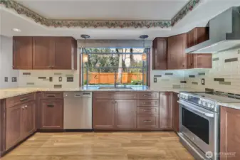 Bright and efficient kitchen workspace with quality appliances, ample storage, and a window overlooking the backyard.
