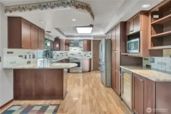 Open kitchen layout flows seamlessly into nearby living spaces, making entertaining effortless. Notice the wine refrigerator on the right!