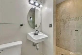 Here is a cloer look at the tastefully updated bathroom featuring a beautifully tiled shower and modern fixtures.