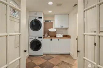This enormous laundry room has full size stack washer and dryer and lots of storage. The second bath is off to the right.