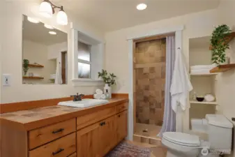 This luxurious bathroom features extensive tile work and an oversized vanity just off the oversized shower.